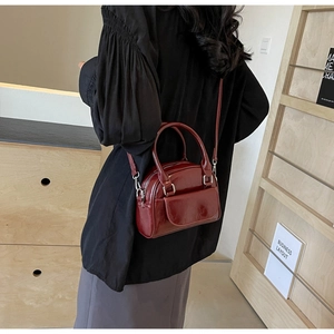 Details der weinroten Lackleder-Handtasche mit Hochglanz-Finish und Silberbeschlägen