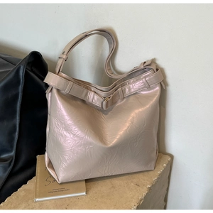 Detail of champagne metallic tote bag showing premium pearlescent texture and buckle strap