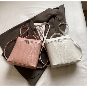 Dettaglio di zaini con motivo a coccodrillo rosa e bianco su un elegante blazer