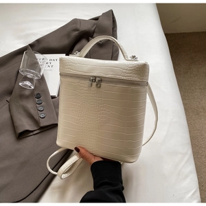 Dettaglio della trama a coccodrillo bianco sporco su una borsa a zaino versatile