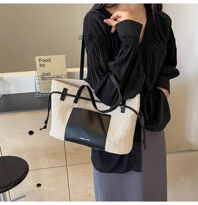 Detail of woven tote bag showing contrast leather trim and side drawstring feature