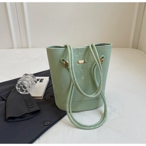 Dettaglio della borsa a secchiello verde menta con trama in pelle e hardware dorato