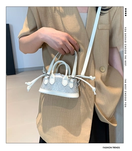 Detail of white mini rhinestone handbag with top handles and shoulder strap