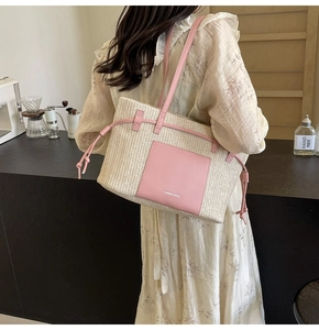 Detail of woven straw tote bag with pink leather pockets and stylish side drawstring knots