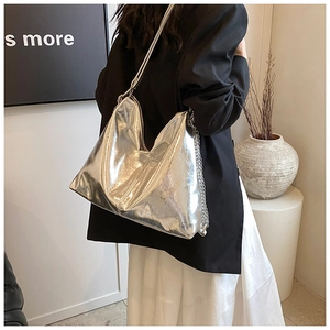 Detail of silver metallic tote bag with chain strap and soft glossy texture finish