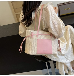 Detail of a woven straw tote with pink leather pocket on a model for beach vacation