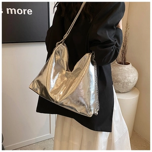 Detail of silver metallic tote bag with wrinkled texture and stylish metal chain strap