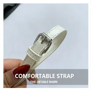 Detail view of the white leather strap with silver metal buckle and neat stitching