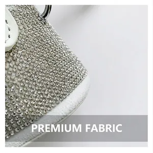 Detailed close-up of premium sparkling rhinestones and white leather trim on handbag