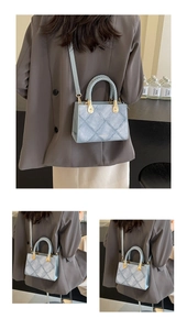 Light blue quilted crossbody bag with woven handle and gold hardware shown on a model