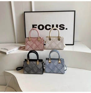 Close-up of four colorful quilted crossbody bags with woven handles and metal accents