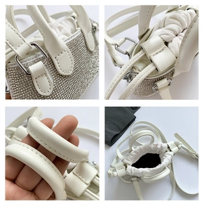 Close-up of white rhinestone studded mini bag with drawstring lining and silver hardware