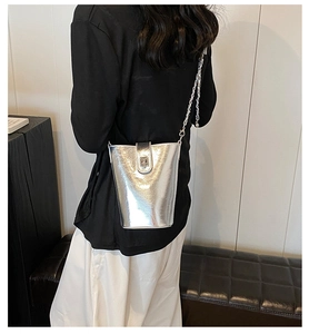 Sac seau argenté métallisé avec bandoulière chaîne porté par un mannequin pour le style