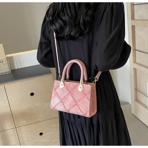 Detail view of pink quilted square handbag with gold hardware and fashion logo