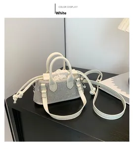Detailed view of a white mini square bag featuring silver rhinestones and a drawstring insert