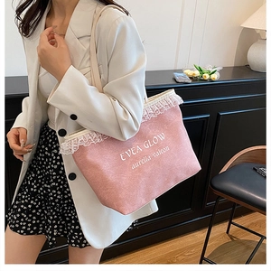 Détail d'un sac cabas en denim rose avec bordure en dentelle blanche et texte brodé