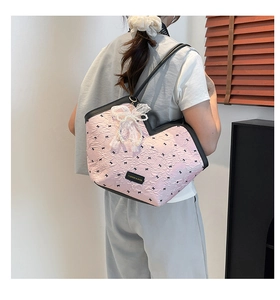 Detailed view of pink floral tote bag with lace bow accessory and pearl detail