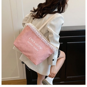 Pink canvas tote bag with white lace trim and artistic lettering shown on shoulder