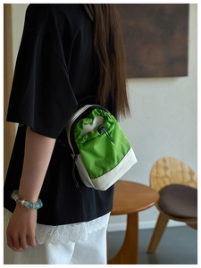 Detalle del bolso deportivo verde neón con cordón y correa de hombro ajustable en un modelo