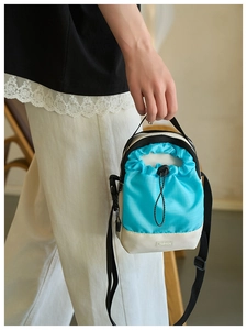 Detalle del bolso tote de nailon bicolor con cierre de cordón y parche de logo Fashion