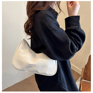 Chic white crescent hobo bag in polished oil wax leather worn as a shoulder bag