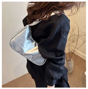 Side view of a silver metallic hobo bag worn on the shoulder with a smooth PU finish