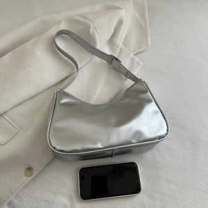 Detailed top view of a silver metallic crescent hobo bag with a matching adjustable strap