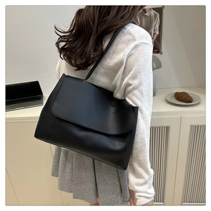 Model view showing the back profile of a black faux leather tote bag for daily commute
