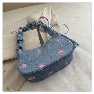 Detail of floral print denim shoulder bag with scrunchie handle and rose patterns