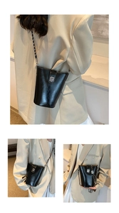 Détail du sac seau noir élégant avec texture en cuir brillant et bandoulière chaîne