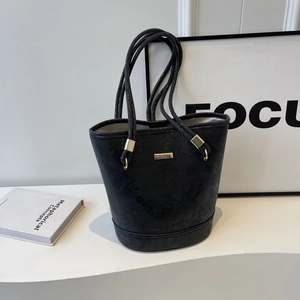 Borsa a secchiello nera testurizzata da donna con anelli dorati e tracolla sottile