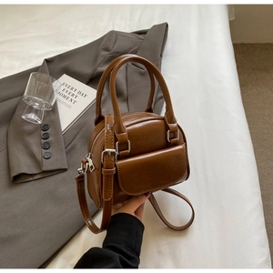 Detailed shot of brown vintage shell bag with polished leather and silver hardware details