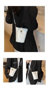 Détails de ce sac seau blanc avec fermoir rotatif argenté et bandoulière en chaîne métal