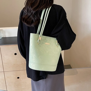 Borsa a secchiello verde menta minimalista con texture marmo e dettagli dorati