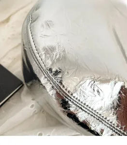 Nahaufnahme der silbernen Satteltasche mit glänzendem Falten-Kunstleder und Metallic-Look