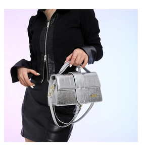 Detailed view of silver crocodile embossed leather texture and gold metal hardware lock