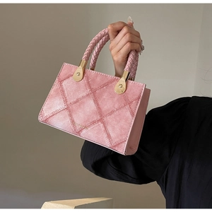 Pink quilted crossbody bag with woven handle and polished gold metal buckles
