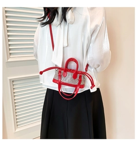 Detail of red rhinestone mini bag showing drawstring closure and leather shoulder strap