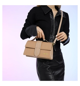 Detail of beige quilted PU leather crossbody bag with gold logo and elegant shoulder strap