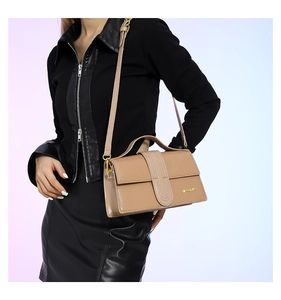 Khaki crossbody bag detail showing leather texture and adjustable shoulder strap on a model