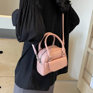 Rosa glänzende Mini-Quadrat-Handtasche mit Doppelgriffen und Umhängeriemen am Modell getragen