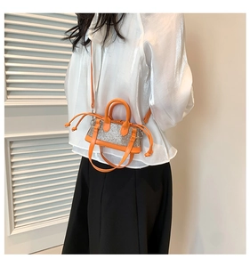 Detailed view of orange rhinestone mini bag styled with a white shirt and black skirt