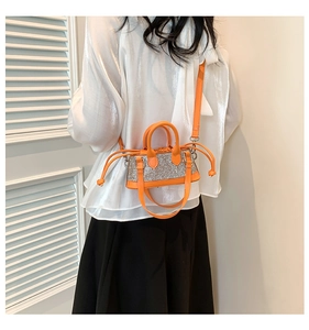 Detail of bright orange rhinestone mini handbag with drawstring and adjustable strap
