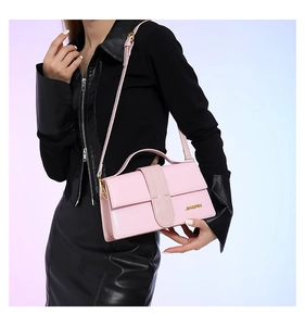 Pink crossbody bag with JINGPIN metal logo and fine textured synthetic leather material
