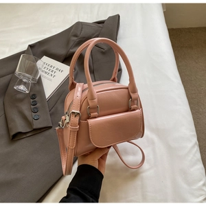 Close-up of pink mini shell bag with smooth PU leather finish and silver hardware details