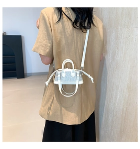 Silver rhinestone mini handbag shown with crossbody strap on model in a minimalist room