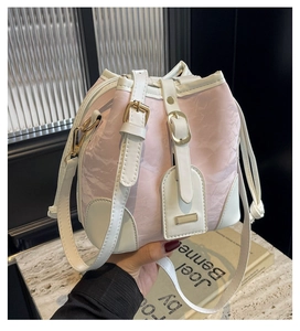 Detail der rosa-weißen Beuteltasche mit Faltenstruktur und goldenen Schnallenakzenten