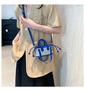 Close-up of klein blue mini rhinestone bag with drawstring closure and dual handles