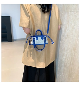 Detail of a mini blue leather handbag with silver rhinestones and a side drawstring knot