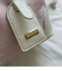 Detail der rosa Bucket Bag mit Marmormuster, Goldbeschlägen und weißem Lederbesatz